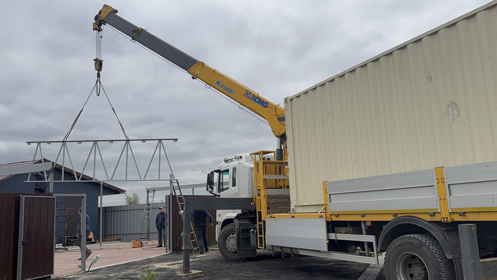 auto2help.ru,  при помощи крана-манипулятора поднимаем фермы для навеса и монтируем их на высоту второго этажа. г.Бронницы, коттеджный поселок, вдоль Новорязанского шоссе , трасса М-5